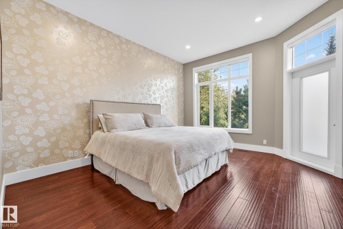 Bedroom with wallpapered walls, dark wood finished floors, recessed lighting, and an accent wall - 940 Haliburton Road, Edmonton, AB - Indoor Photo Showing Bedroom