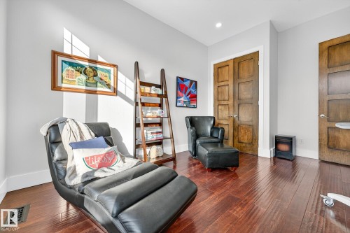 Living area featuring a wood stove, wood finished floors, and recessed lighting - 940 Haliburton Road, Edmonton, AB - Indoor