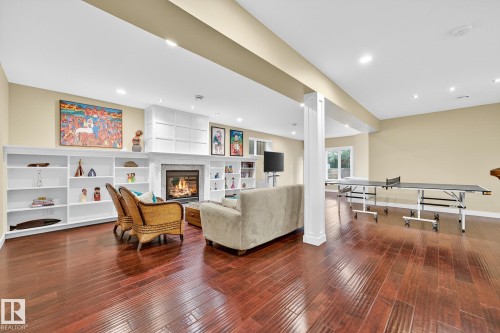Living area with a glass covered fireplace, dark wood finished floors, and recessed lighting - 940 Haliburton Road, Edmonton, AB - Indoor Photo Showing Other Room With Fireplace
