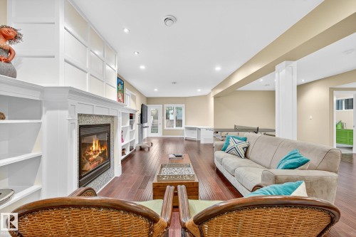 Living room featuring a tile fireplace, dark wood-style floors, recessed lighting, and built in shelves - 940 Haliburton Road, Edmonton, AB - Indoor Photo Showing Living Room With Fireplace