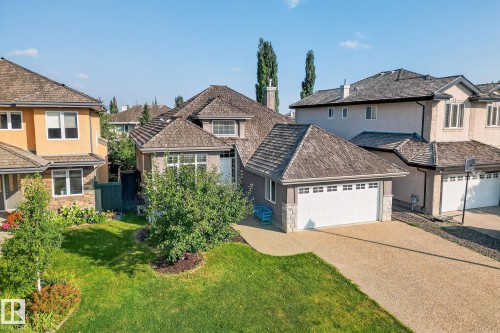 Traditional-style home featuring stucco siding, stone siding, driveway, and a residential view - 940 Haliburton Road, Edmonton, AB - Outdoor