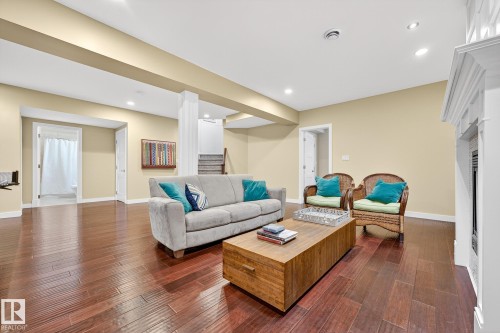 Living area featuring dark wood-style floors, stairs, and recessed lighting - 940 Haliburton Road, Edmonton, AB - Indoor