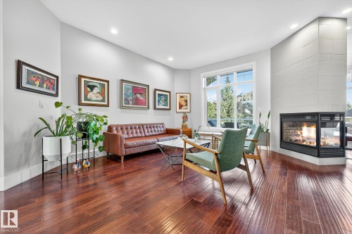 Living area featuring hardwood / wood-style floors, recessed lighting, a multi sided fireplace, and a high ceiling - 940 Haliburton Road, Edmonton, AB - Indoor Photo Showing Living Room With Fireplace