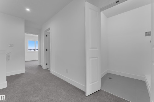 Hallway with light gray carpeting, white baseboards, and bright white walls - 285 Munn Way, Leduc, AB - Indoor Photo Showing Other Room