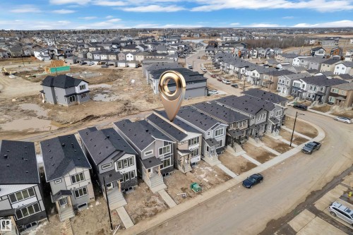 Modern residential development featuring a row of multi-story homes with dark pitched roofs and varying siding materials - 285 Munn Way, Leduc, AB - Outdoor With View