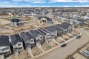Modern residential development featuring a row of multi-story homes with dark pitched roofs and varying siding materials - 285 Munn Way, Leduc, AB  - Outdoor With View 