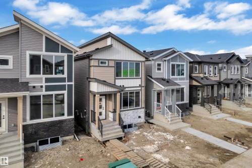 Contemporary facade featuring a mix of horizontal siding, vertical siding, and stone veneer accents - 285 Munn Way, Leduc, AB - Outdoor With Facade