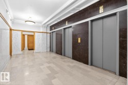 Entryway featuring light-toned tile flooring, marble wainscoting, and wood-paneled doors - 