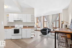 Kitchen featuring white cabinetry, a white electric range, and wood-finish countertops - 