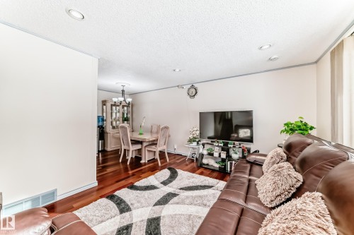 The living area features hardwood flooring, recessed lighting, and ample natural light from the window - 8733 181A Street Nw, Edmonton, AB - Indoor Photo Showing Living Room
