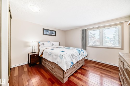 This room features rich hardwood flooring and a window providing natural light - 8733 181A Street Nw, Edmonton, AB - Indoor Photo Showing Bedroom
