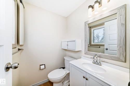 Bathroom featuring a white vanity with a white countertop and a framed mirror - 8733 181A Street Nw, Edmonton, AB - Indoor Photo Showing Bathroom