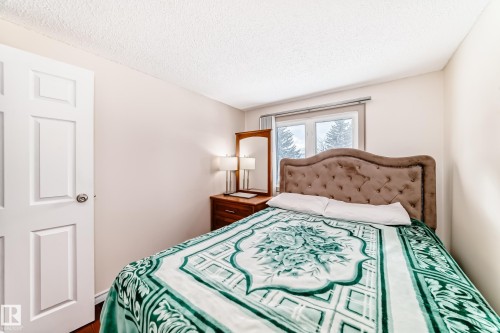 This bedroom features a window, a white paneled door, and light-colored walls - 8733 181A Street Nw, Edmonton, AB - Indoor Photo Showing Bedroom