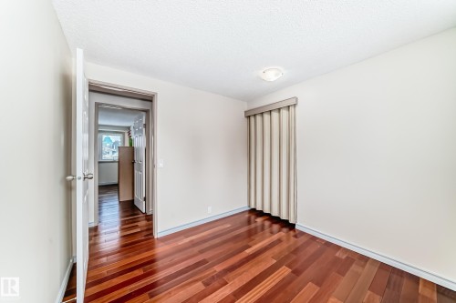 The room features rich hardwood flooring and light-colored walls - 8733 181A Street Nw, Edmonton, AB - Indoor Photo Showing Other Room