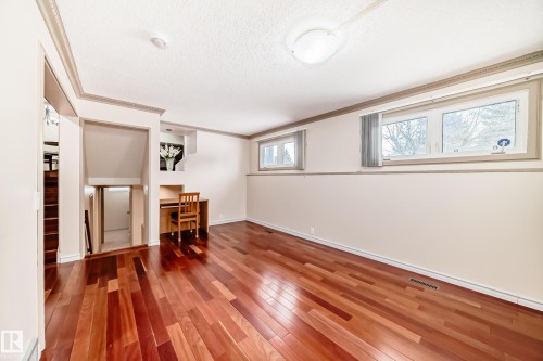 This inviting space features rich hardwood flooring, a built-in desk area, and windows providing natural light - 8733 181A Street Nw, Edmonton, AB - Indoor Photo Showing Other Room