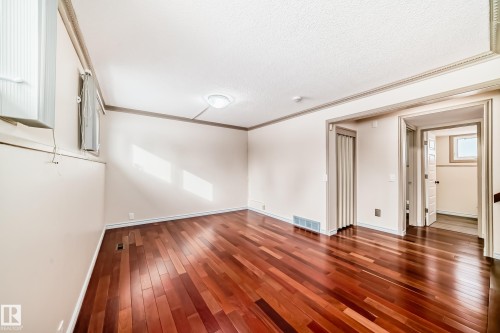 This inviting room features polished hardwood flooring and light-colored walls - 8733 181A Street Nw, Edmonton, AB - Indoor Photo Showing Other Room