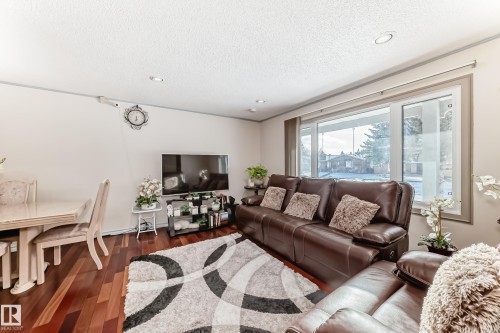The living space features hardwood floors, a large window, and recessed lighting - 8733 181A Street Nw, Edmonton, AB - Indoor Photo Showing Living Room