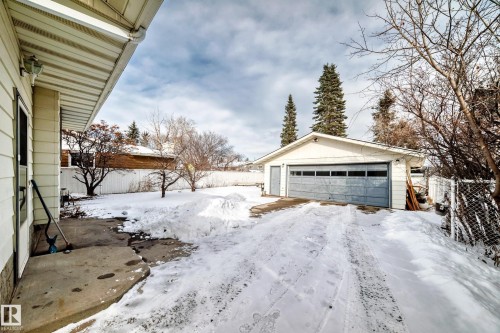 The property features a detached garage with a light-colored exterior and a gray garage door, complemented by a concrete driveway - 8733 181A Street Nw, Edmonton, AB - Outdoor