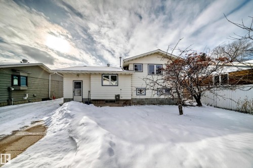 The property features a white exterior, a fenced yard, and a paved driveway - 8733 181A Street Nw, Edmonton, AB - Outdoor