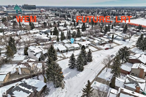 Aerial view of the neighborhood showing residential properties with snow-covered roofs and mature evergreen trees - 8733 181A Street Nw, Edmonton, AB - Outdoor With View