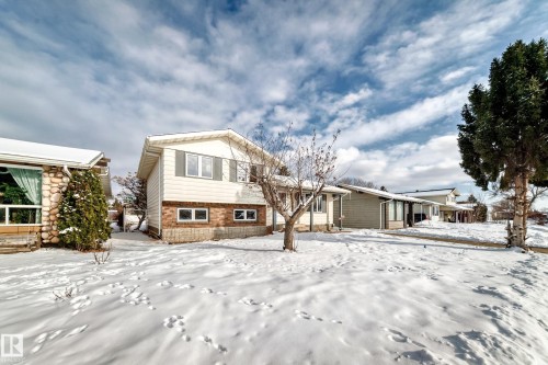 The property features a two-story design with white siding and brick accents on the lower level - 8733 181A Street Nw, Edmonton, AB - Outdoor