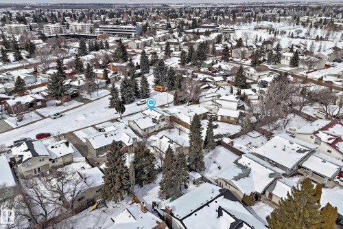 Aerial view of the property and its surrounding neighbourhood, featuring a mix of residential homes with snow-covered roofs and mature trees - 8733 181A Street Nw, Edmonton, AB - Outdoor With View