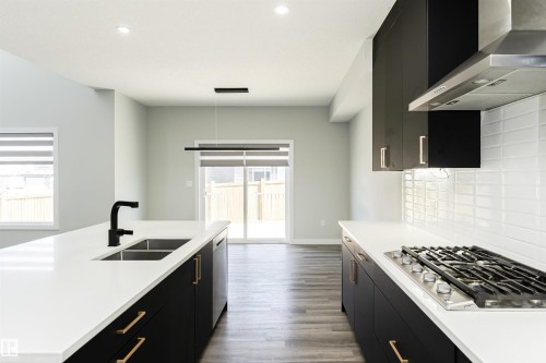 Modern kitchen featuring black cabinetry, white countertops, and stainless steel appliances - 5386 Kimball Place, Edmonton, AB - Indoor Photo Showing Kitchen With Double Sink With Upgraded Kitchen