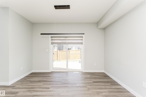 Spacious room with wood-finish flooring, light grey painted walls, and white trim - 5386 Kimball Place, Edmonton, AB - Indoor Photo Showing Other Room
