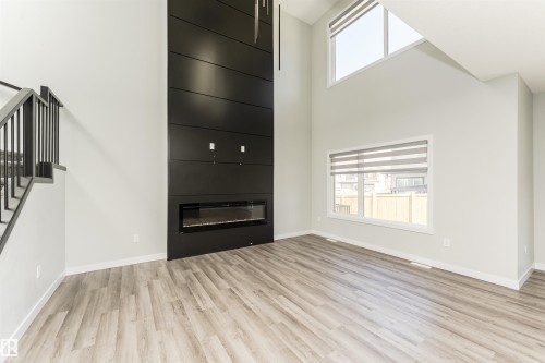 Soaring vaulted ceilings with an expansive black panel feature wall and linear electric fireplace - 5386 Kimball Place, Edmonton, AB - Indoor With Fireplace
