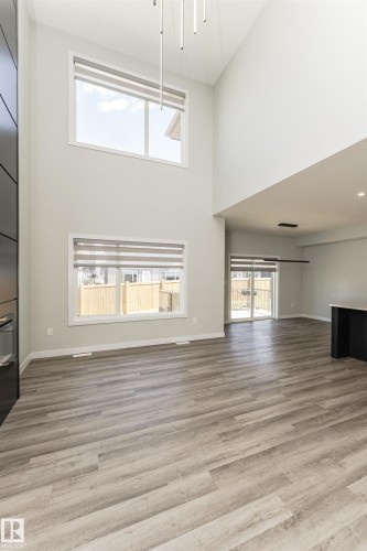 Vaulted ceilings with contemporary linear pendant lighting and light wood-finish flooring - 5386 Kimball Place, Edmonton, AB - Indoor Photo Showing Other Room