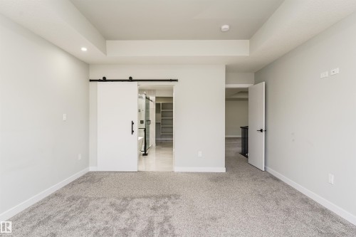 Spacious room featuring light gray carpeting, crisp white baseboards, and neutral wall tones - 5386 Kimball Place, Edmonton, AB - Indoor Photo Showing Other Room