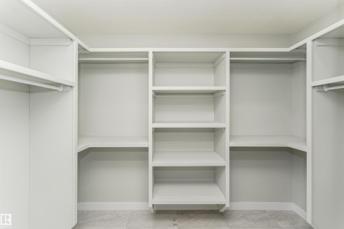 Custom closet system featuring multiple hanging rods and shelving units - 5386 Kimball Place, Edmonton, AB - Indoor With Storage