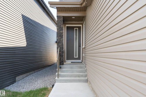 Contemporary dark entry door with decorative glass panel and white trim - 5386 Kimball Place, Edmonton, AB - Outdoor With Exterior