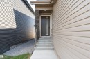 Contemporary dark entry door with decorative glass panel and white trim - 5386 Kimball Place, Edmonton, AB  - Outdoor With Exterior 