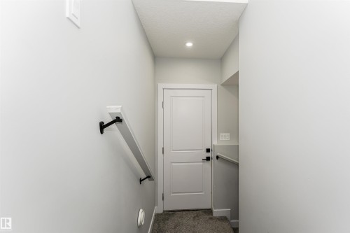 Stairwell with light gray walls, white trim, and a white interior door featuring matte black hardware - 5386 Kimball Place, Edmonton, AB - Indoor Photo Showing Other Room