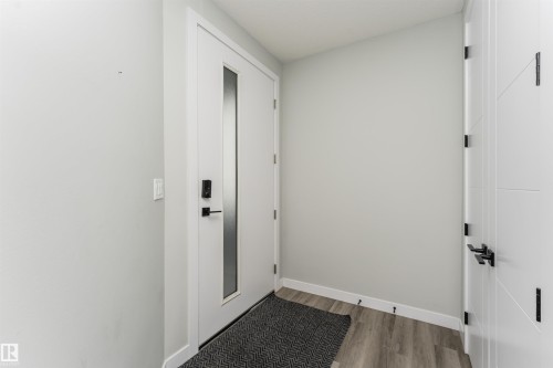 Modern entry door with frosted glass insert, smart lock, and matte black hardware - 5386 Kimball Place, Edmonton, AB - Indoor Photo Showing Other Room