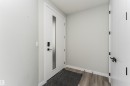 Modern entry door with frosted glass insert, smart lock, and matte black hardware - 5386 Kimball Place, Edmonton, AB  - Indoor Photo Showing Other Room 