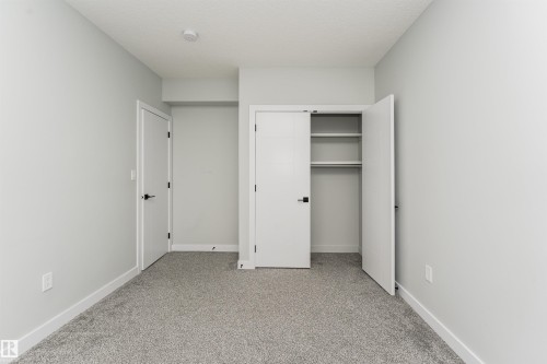 Neutral gray carpeting complemented by matching wall tones - 5386 Kimball Place, Edmonton, AB - Indoor Photo Showing Other Room