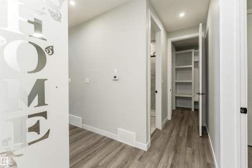 Well-lit hallway featuring wood-finish flooring, light gray walls, white baseboards, and recessed lighting - 5386 Kimball Place, Edmonton, AB - Indoor Photo Showing Other Room