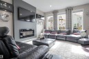 Living area featuring a modern wall-mounted fireplace, recessed lighting, and three large windows providing ample natural light - 1728 53 Street, Edmonton, AB  - Indoor Photo Showing Living Room With Fireplace 