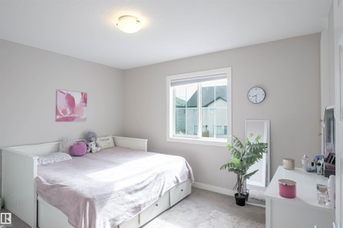 Carpeted bedroom with a window featuring white trim and a neutral wall color - 1728 53 Street, Edmonton, AB - Indoor Photo Showing Bedroom