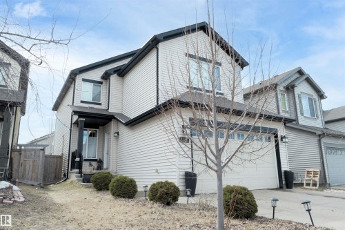Two-story residence featuring light-colored siding with dark trim, an attached two-car garage, and a covered front entry - 1728 53 Street, Edmonton, AB - Outdoor