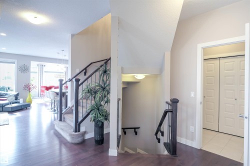 Staircase featuring dark wood handrails, wrought iron balusters, and carpeted treads - 1728 53 Street, Edmonton, AB - Indoor Photo Showing Other Room