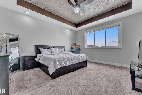 Spacious room featuring a tray ceiling with decorative paneling, recessed lighting, and a modern ceiling fan - 1404 25 Street, Edmonton, AB - Indoor Photo Showing Bedroom