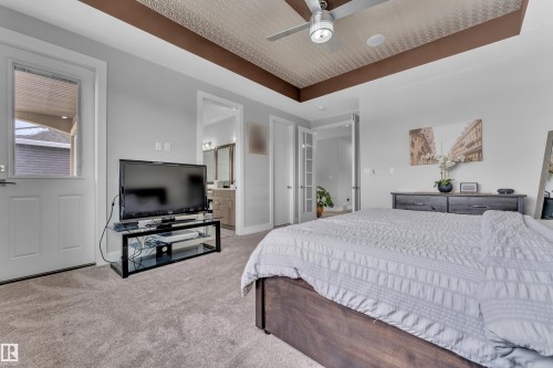 Bedroom featuring textured ceiling detail with a ceiling fan, light gray wall paint, and gray carpeting - 1404 25 Street, Edmonton, AB - Indoor Photo Showing Bedroom