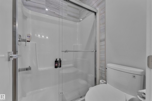 Shower enclosure with clear glass sliding doors and polished chrome hardware - 1404 25 Street, Edmonton, AB - Indoor Photo Showing Bathroom