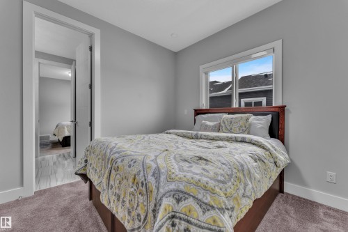 Bedroom featuring neutral gray walls, plush carpeting, white trim, and a window with exterior views - 1404 25 Street, Edmonton, AB - Indoor Photo Showing Bedroom