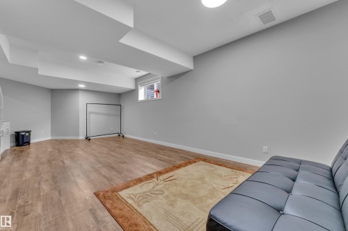 Spacious lower-level room featuring wood-finish flooring, recessed lighting, and a window - 1404 25 Street, Edmonton, AB - Indoor