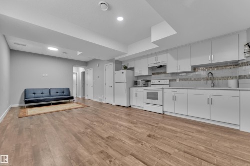 Open-concept living space featuring wood-finish flooring, recessed lighting, and a full kitchen - 1404 25 Street, Edmonton, AB - Indoor Photo Showing Kitchen