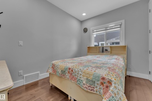 Recessed lighting illuminates this room, featuring wood-finish flooring and a window with a white frame - 1404 25 Street, Edmonton, AB - Indoor Photo Showing Bedroom